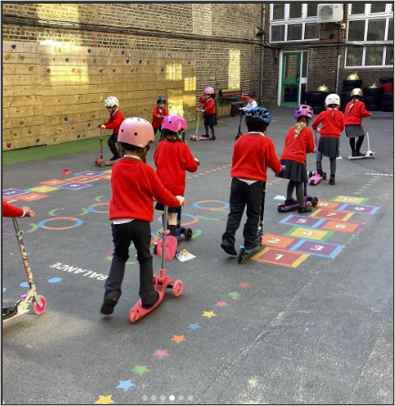 Children riding scooters around a playground