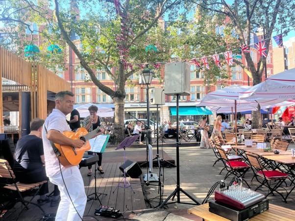 A guitarist plays to a crowd of people.