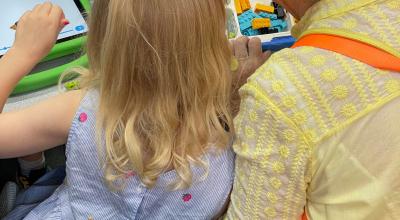 A woman and young girl playing with Lego.