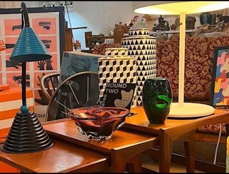 Selection of antique lamps, tables and ornaments arranged in a showroom