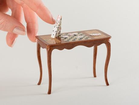 A finger moves a small object on a table.
