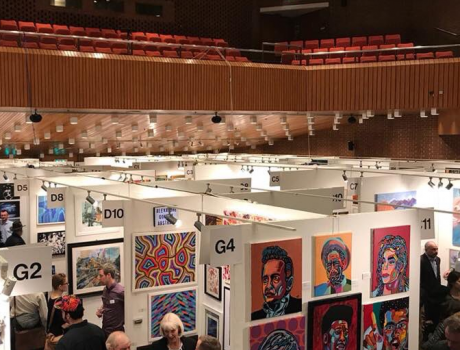 Art fair with paintings on stands.